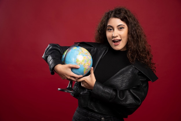 Foto grátis mulher encaracolada segurando o globo.