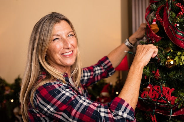 Foto grátis mulher enfeitando a árvore de natal