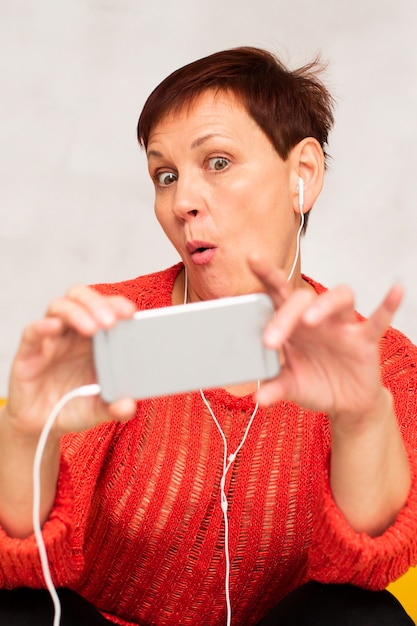 Foto grátis mulher engraçada, ouvindo música e tomando uma selfie