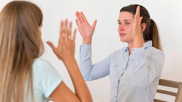 Mulher ensinando língua de sinais a outra mulher