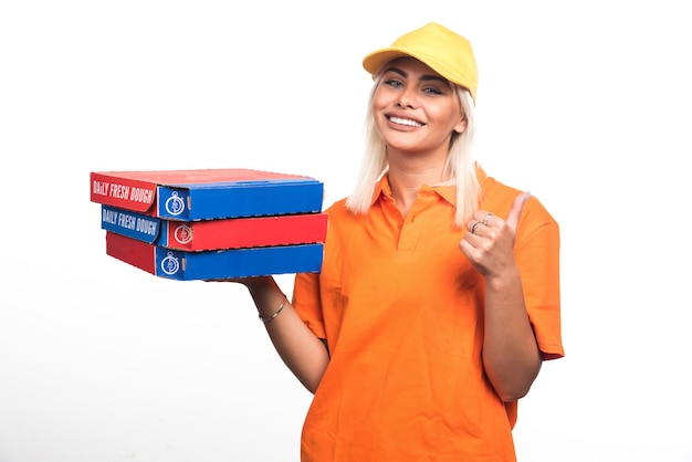 Mulher entregadora de pizza segurando pizza no fundo branco, apontando o dedo para o lado. Foto de alta qualidade