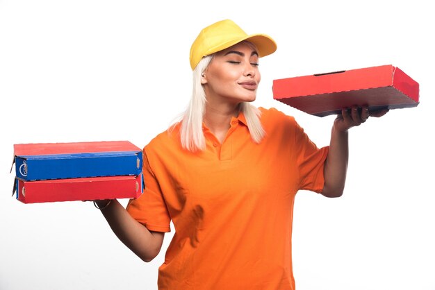 Mulher entregadora de pizza segurando pizza no fundo branco enquanto sorria. Foto de alta qualidade