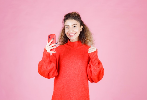 Foto grátis mulher enviando mensagens de texto em seu novo smartphone e se sentindo feliz.