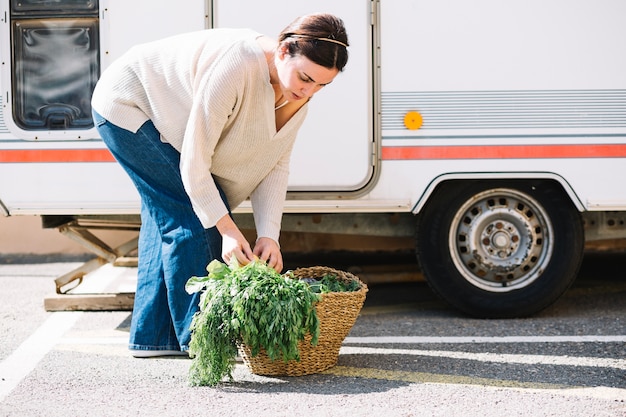 Mulher escolhendo vegetais da cesta
