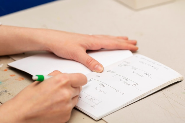 Mulher escrevendo medidas diferentes em um caderno