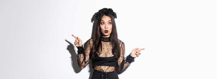 Foto grátis mulher espantada e assustada com fantasia de bruxa parecendo impressionada apontando os dedos para o lado, mas olhe para a esquerda