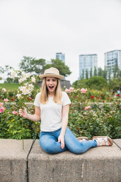 Mulher espantada sentada com buquê de flores