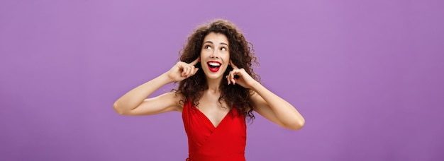 Foto grátis mulher esperando entretida por estrondo alto e fogos de artifício sorrindo amplamente olhando para o canto superior direito c