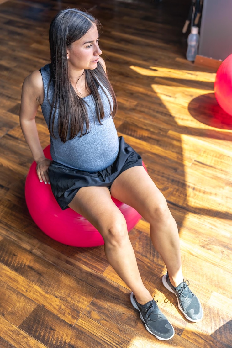 Foto grátis mulher esportiva grávida com bola em forma no ginásio o conceito de estilo de vida esportivo