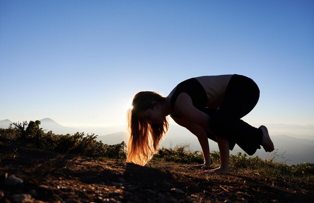 Mulher está praticando ioga em pose de vaga-lume