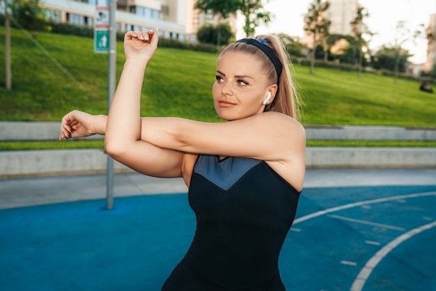 Foto grátis mulher estica os músculos no ginásio ao ar livre