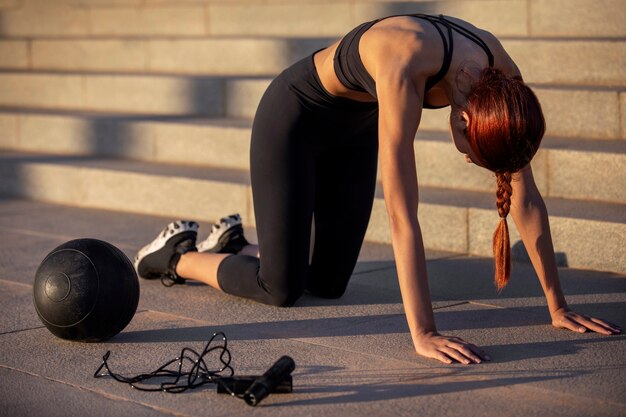 Mulher esticando e se preparando para exercícios ao ar livre