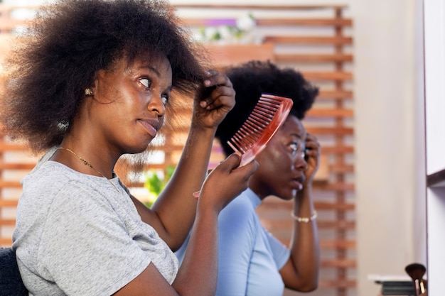 Foto grátis mulher estilista cuidando do cabelo afro de seu cliente