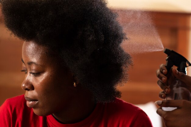 Mulher estilista cuidando do cabelo afro de seu cliente