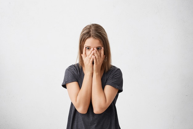 Foto grátis mulher estressada e assustada com uma camiseta casual cobrindo o rosto, sentindo medo