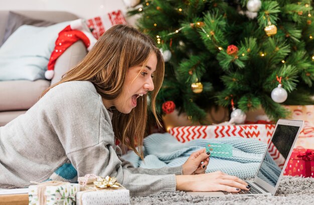 Mulher excitada compras na árvore de natal