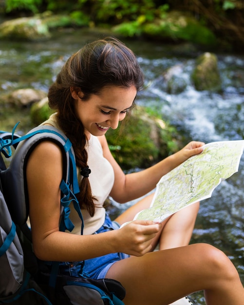 Mulher explorando a natureza e usando o mapa