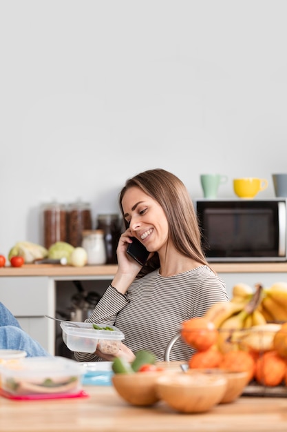 Mulher falando ao telefone e comer