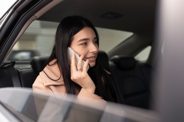 Mulher falando ao telefone enquanto está em um táxi