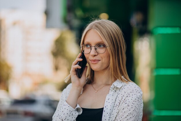 Mulher falando ao telefone fora da rua