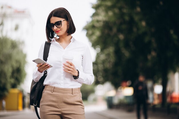 Mulher falando ao telefone fora das ruas da cidade