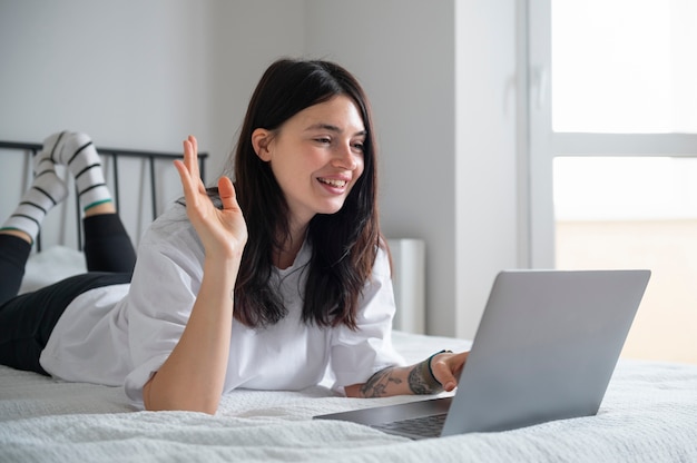 Mulher falando e usando seu laptop em casa durante a quarentena