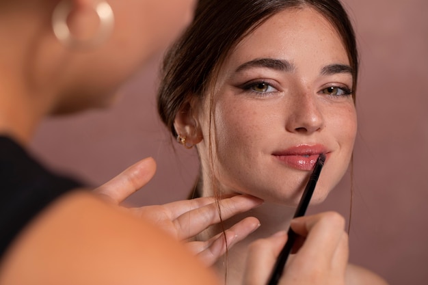 Foto grátis mulher fazendo a maquiagem por um profissional