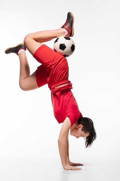 Foto grátis mulher fazendo acrobacias com bola de futebol