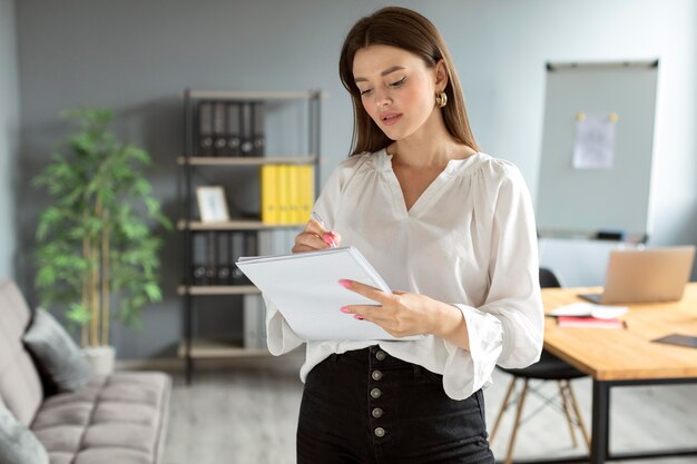 Mulher fazendo anotações no caderno no trabalho