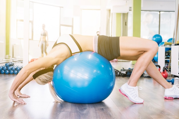 Foto grátis mulher fazendo exercícios na bola de ajuste