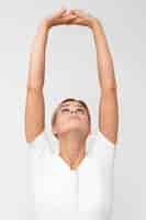 Foto grátis mulher fazendo fisioterapia enquanto levanta os braços