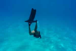 Foto grátis mulher fazendo mergulho livre com nadadeiras debaixo d'água