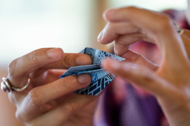 Mulher fazendo origami com papel japonês