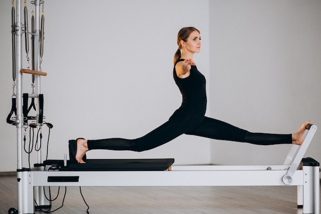 Foto grátis mulher fazendo pilates em um reformador