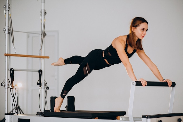 Mulher fazendo pilates em um reformador