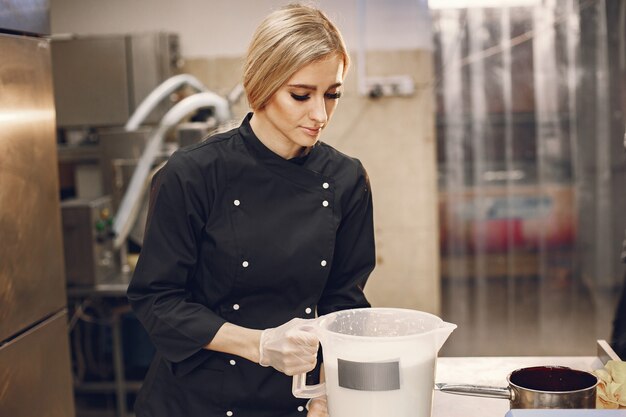 Mulher fazendo sorvete na cozinha comercial.