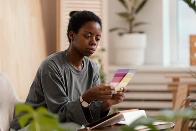 Mulher fazendo um plano usando paleta de cores e tablet para redecorar a casa