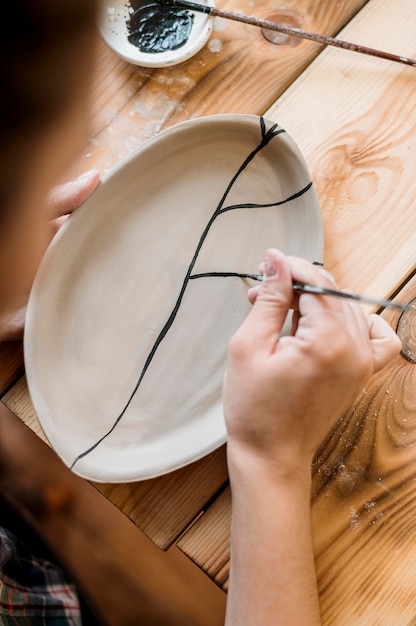 Mulher fazendo uma obra-prima de cerâmica