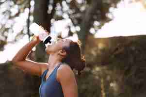 Foto grátis mulher fazendo uma pausa na corrida para beber água
