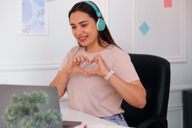 Foto grátis mulher fazendo uma videochamada usando um laptop em casa