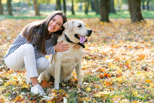 Mulher feliz, abraçando seu cachorro no parque