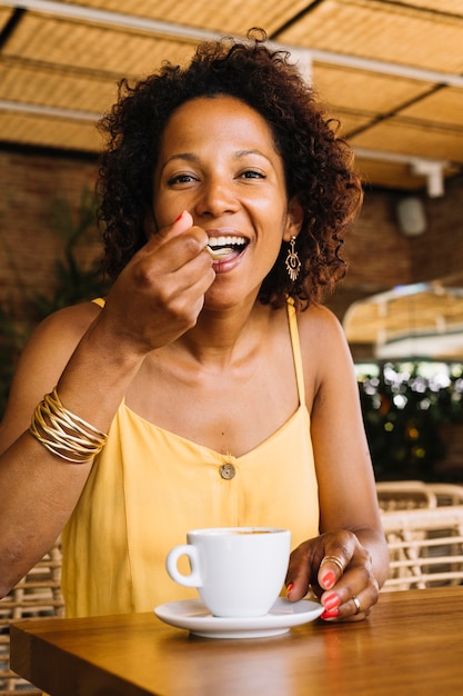 Mulher feliz, apreciando o café cappuccino no café