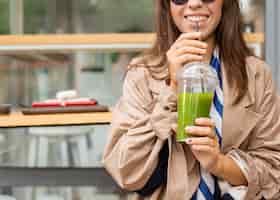 Foto grátis mulher feliz bebendo smoothie verde