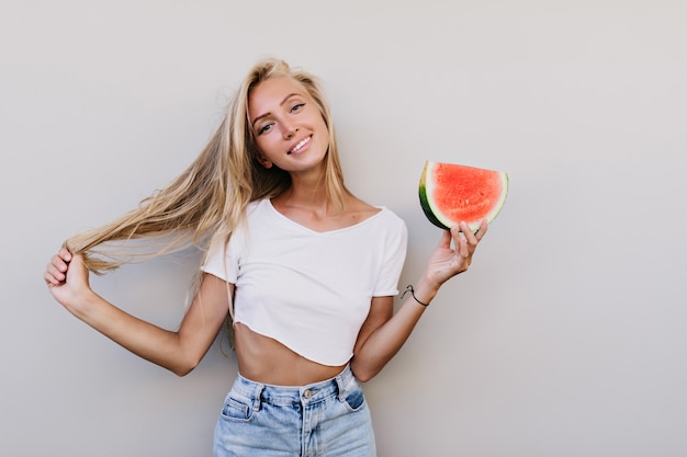 Foto grátis mulher feliz bem vestida segurando uma fatia de melancia.