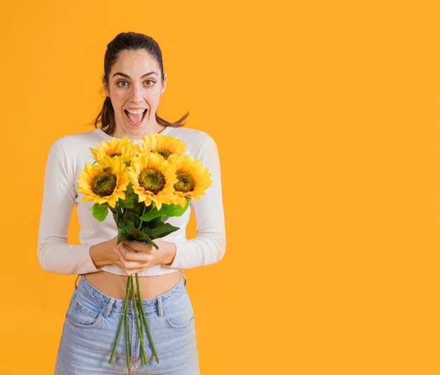 Foto grátis mulher feliz com buquê de girassol