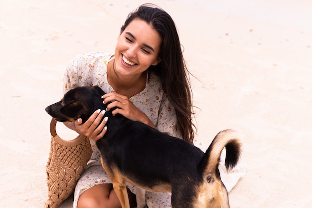 Mulher feliz com cachorro de praia