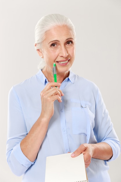 Mulher feliz com caneta e caderno olhando e sorrindo