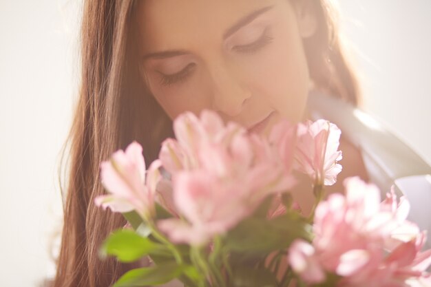 Mulher feliz com flores ao lado de seu rosto