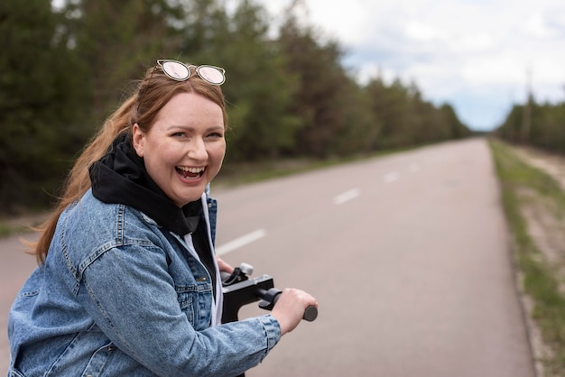 Mulher feliz com tiro médio com scooter