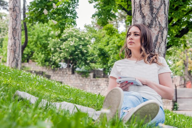 Mulher feliz curtindo a vida no campo com flores. Beleza da natureza, céu nublado azul e campo colorido com flores. Estilo de vida ao ar livre. Conceito de liberdade. Mulher no campo do verão